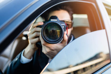 Un investigatore privato fotografa dalla sua macchina