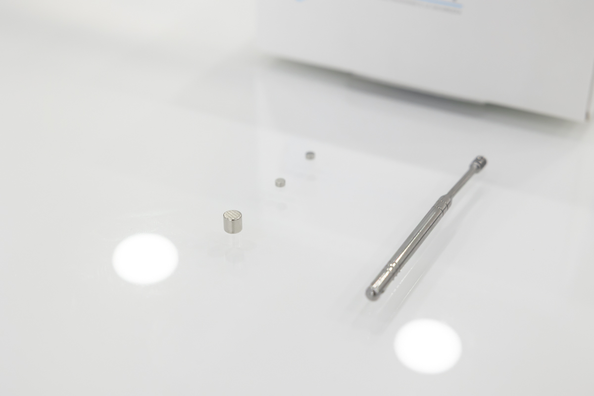 Kit composto da due auricolari nanocalamitati con estrattore metallico e calamita per la rimozione degli auricolari dall'orecchio AURIC.09