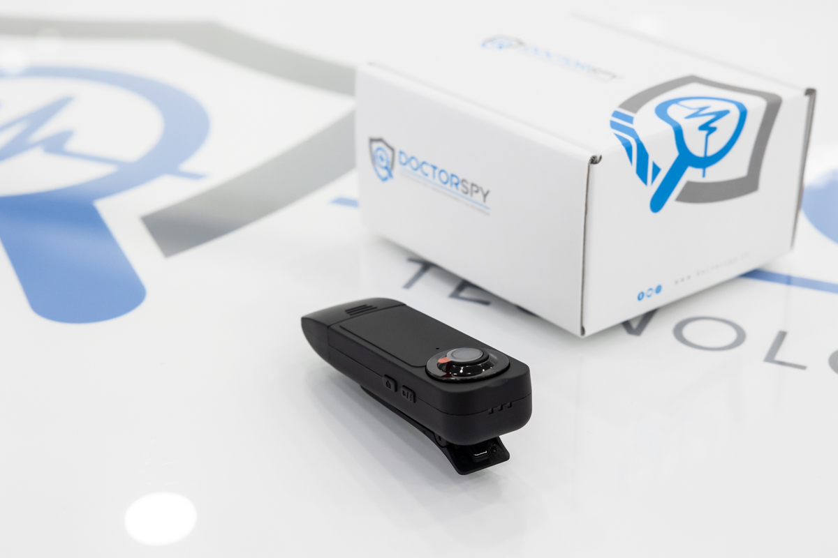 Vista inclinata della bodycam Full HD con clip visibile e scatola brandizzata sullo sfondo CAM.01